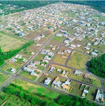 Vista aérea do bairro planejado Nova Amazonas em Iranduba, com ruas definidas e casas construídas, cercado pela floresta amazônica